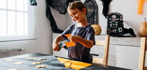 Boy cutting out Halloween decorations