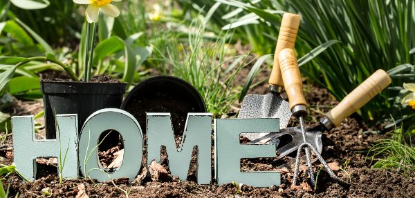 'Home' sign and gardening tools