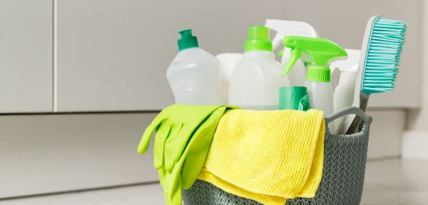 Cleaning products and tools in a bucket.