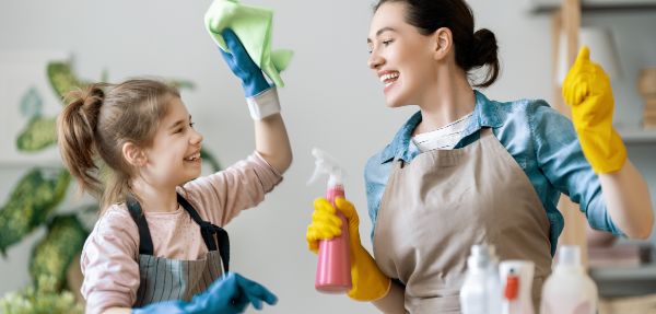 Happy family at home. Mother and daughter doing the cleaning in the house. 