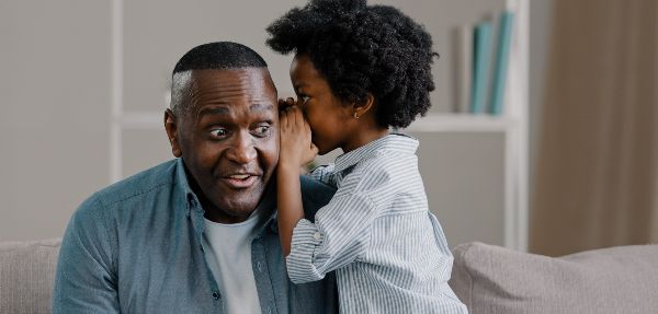 Daughter whispering in her father's ear.