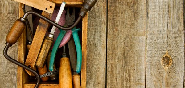 Old tools in toolbox on wooden surface