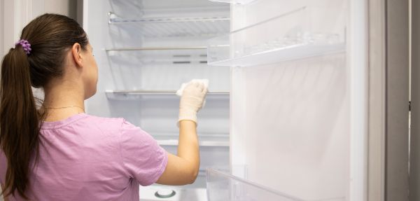 Woman cleaning a fridge.