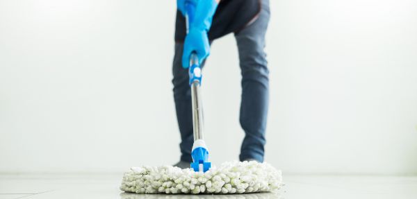 Person cleaning floor with mop.