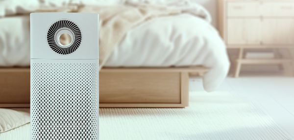 Air purifier in a white bedroom.