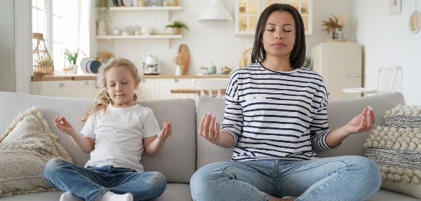 Mom and daughter meditating together.