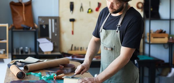 Man in garage sharpening tools.