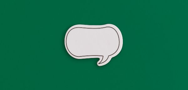 Paper speech bubble on a green background. 