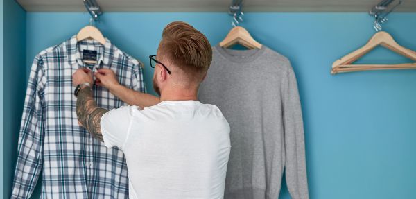 Man organising clothes in his hanging cupboard