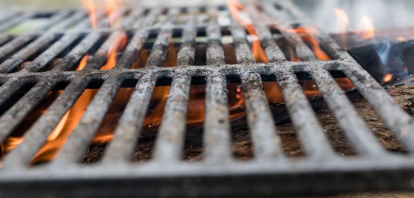 A BBQ grill grate with fire going through it