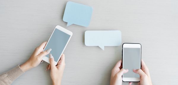 Hands holding phones with speech bubbles above them