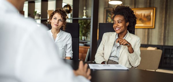 Two businesswomen sitting in a modern office for meetings.