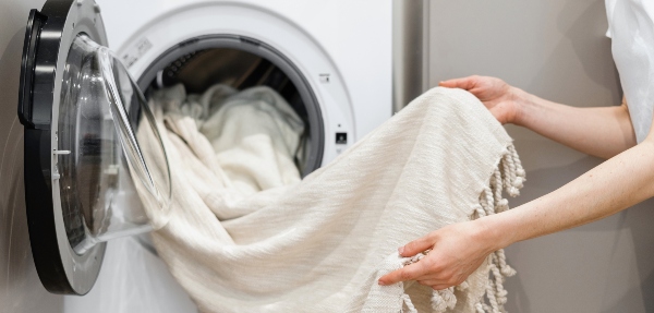 Close-up shot of a person washing curtains in a washing machine