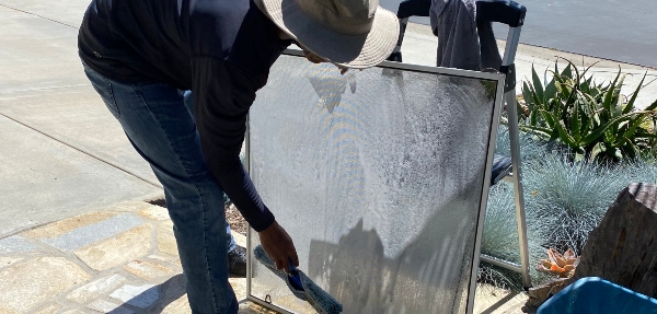 Person cleaning a window screen