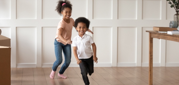 Two siblings running around while playing a game