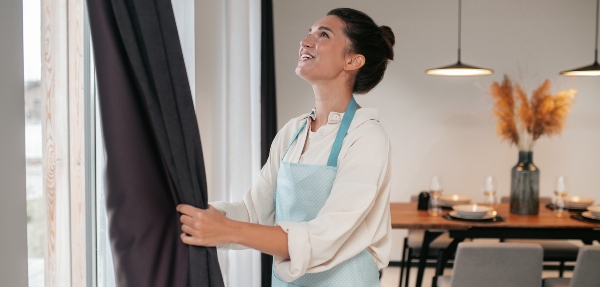 Woman tidying curtains with her hands