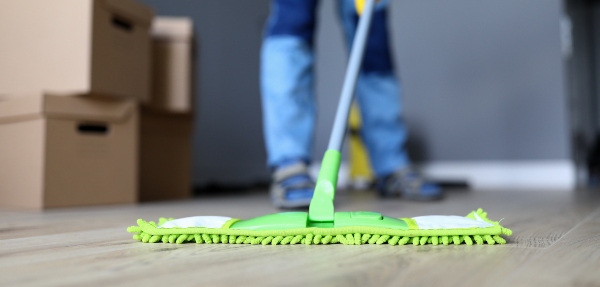 Close-up shot of a person mopping a wooden floor