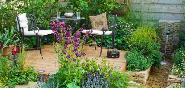 Outdoor garden setup with a table, chairs, and a variety of plants