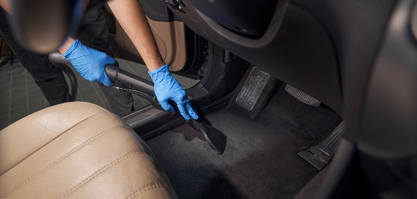 Person vacuuming a car floor