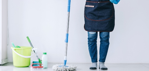 Person standing beside cleaning tools getting ready to clean