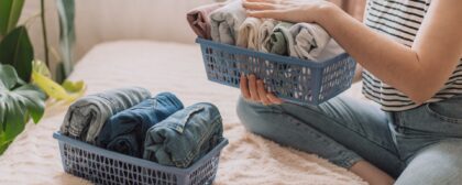 Lady organised her clothes into containers.