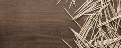 Many wooden toothpicks on a brown table background