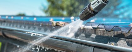 Pressure washer cleaning a roof gutter