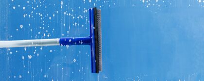 Rubber squeegee cleans a window. Clears a stripe of soapy window.